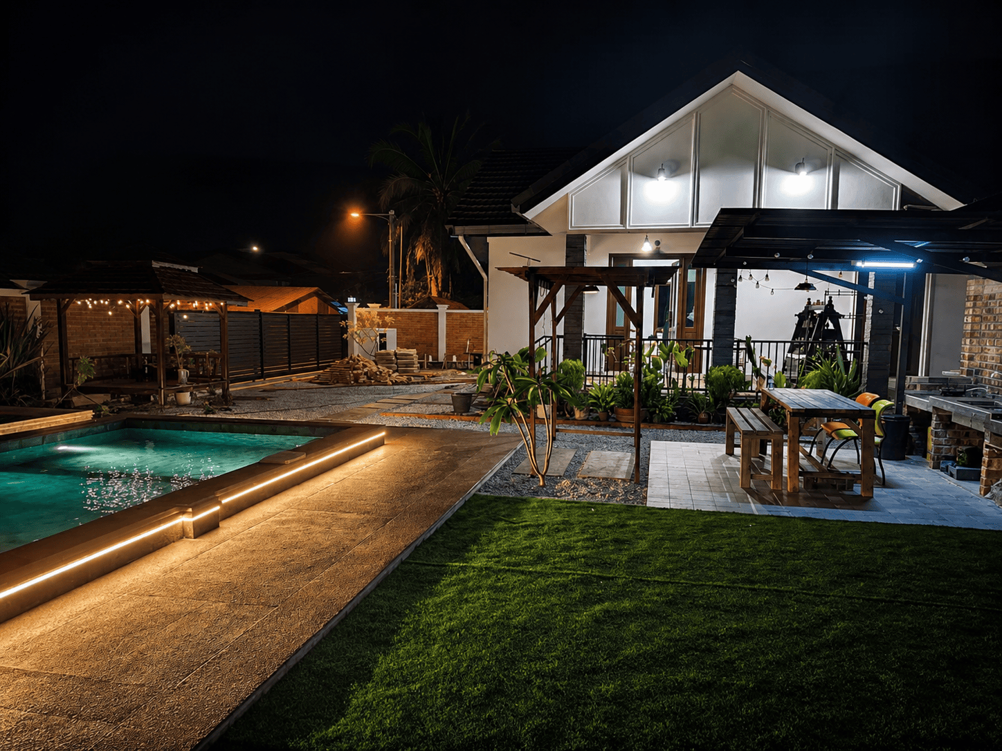 Ellamin Courtyard at night — pool with string lights