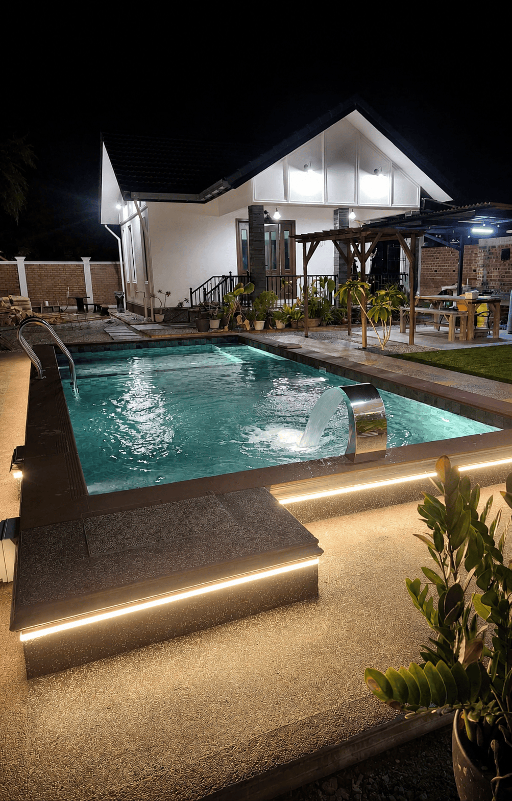 Pool at night with LED lighting and waterfall feature